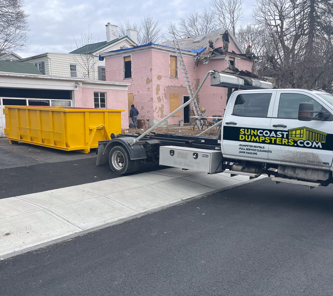 Suncoast Dumpster Truck Unloading a Roll-Off Dumpster in Pinellas County, FL