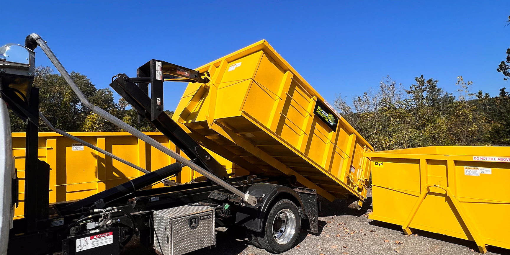 Suncoast Dumpster Rental Truck unloading a 15 Yard Roll-Off Dumpster in Pinellas County, FL